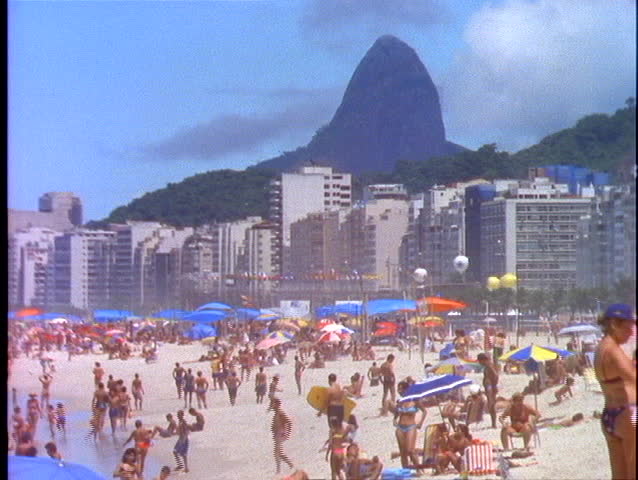 Sunbathers Lie In The Sand On Copacabana Beach In Rio De Janeiro With
