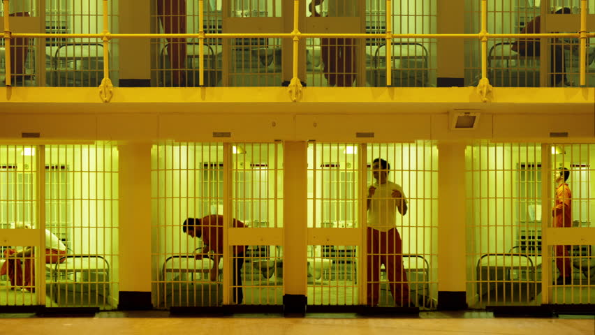 Inmate Standing At The Bars Of His Prison Cell. Neighboring Inmate Can ...