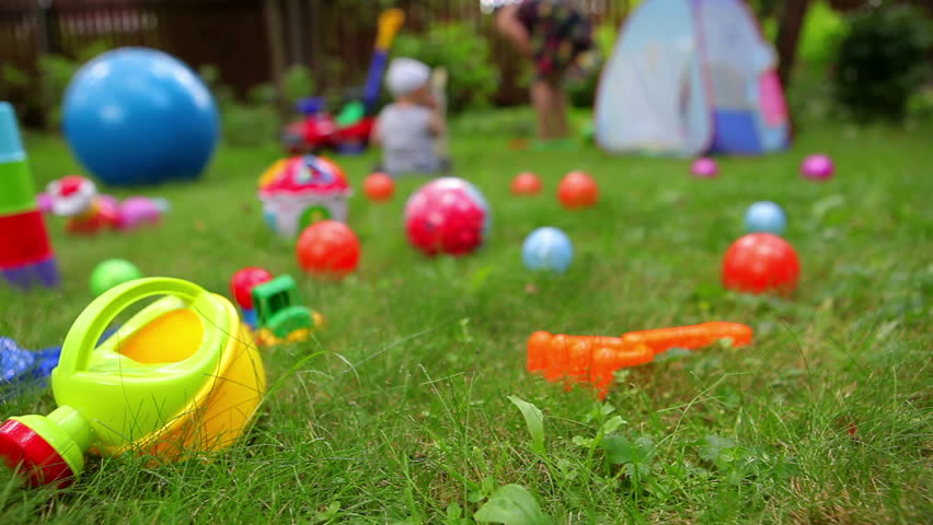 Toys On Grass And Unrecognizable Baby On Background (dolly ...
