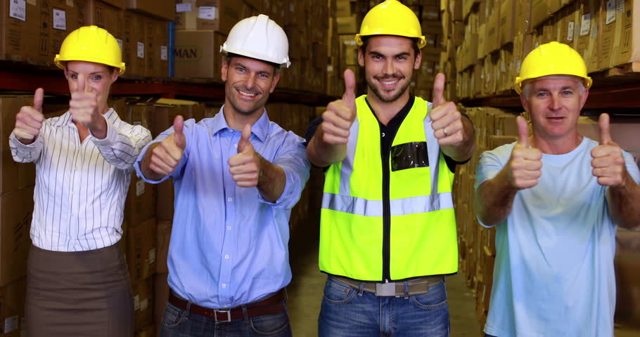 Warehouse Team Smiling And Showing Thumbs Up Together In A Large