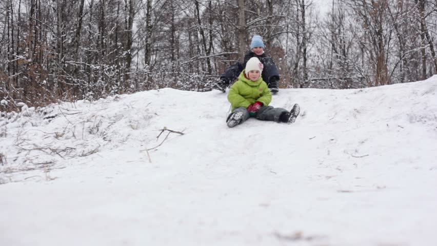 Two Kids Slide On Sled By Snow Slope At Winter Day Stock Footage Video ...