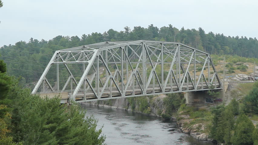 Steel Pratt truss bridge over the French River. Black pickup truck ...