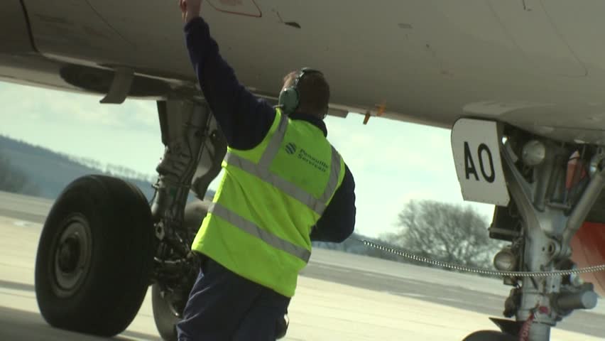 BRISTOL - March 18: An Airline Ramp Agent Makes A Hand Signal As He ...